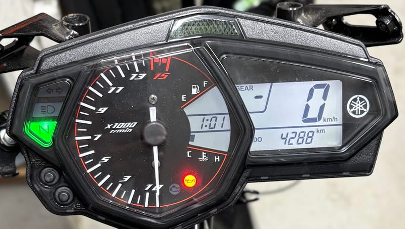 YZF-R25のメーター。燃料計と水温計の間の時計が1:01を表示し、左下に2つのボタンがある