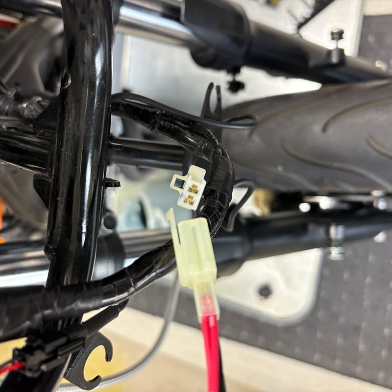 メーターの下でハーネスから出ているポジションランプの2極カプラーと、挿し込む前の電源取出ハーネスのカプラー