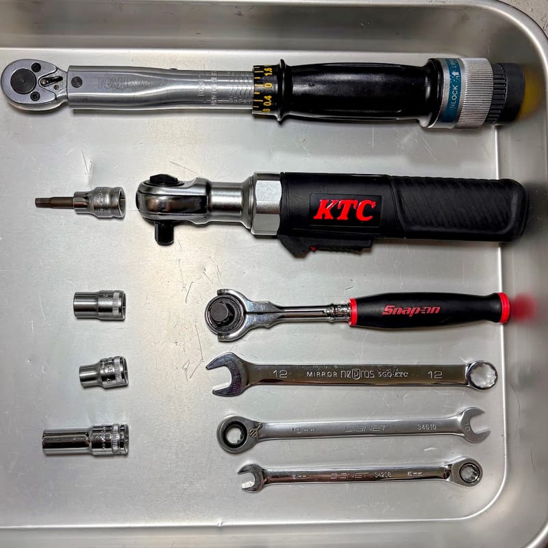 トレーに並べた工具。上から南海部品のトルクレンチ、KTC の電動ラチェット、スナップオンのラチェット、ネプロスの 12mm コンビネーションレンチ、SIGNET のギアレンチ2本。左にソケット3個と六角のビットソケット