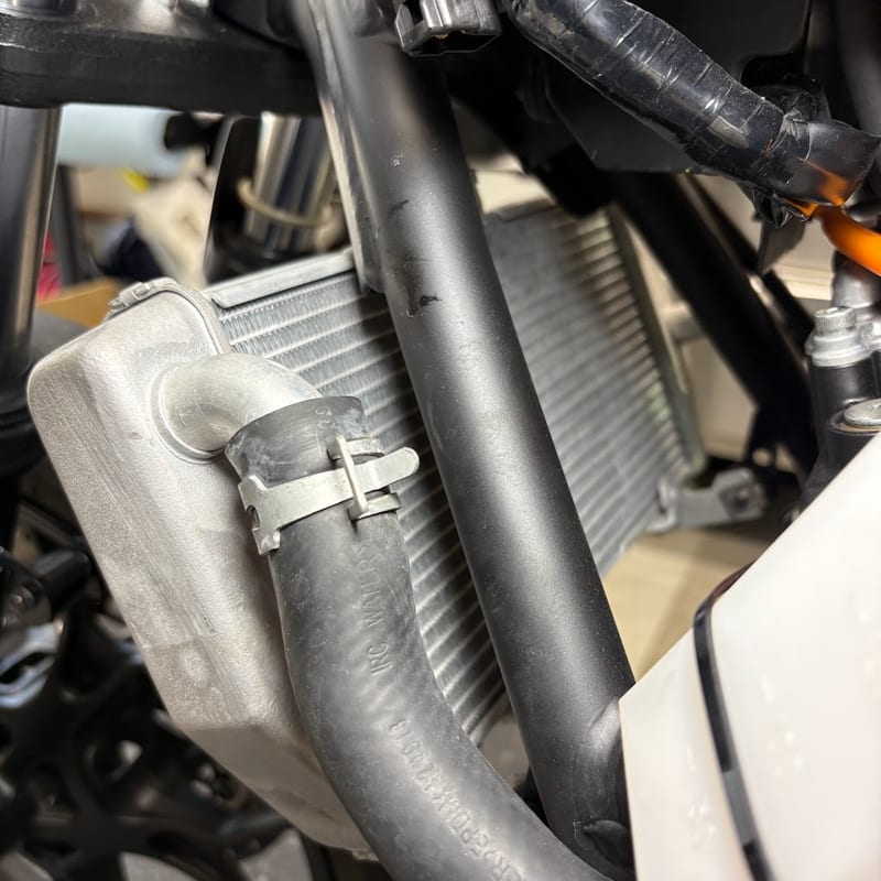 YZF-R3 の車体左側から見たラジエター。フレームのパイプの奥にラジエターのコアが見え、裏にあったファンは外してある