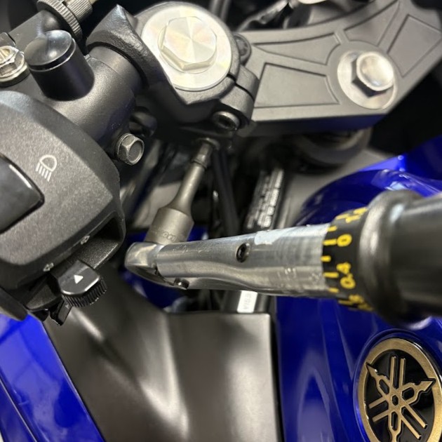 目盛り付きトルクレンチでトップブリッジのピンチボルトを締め直しているところ