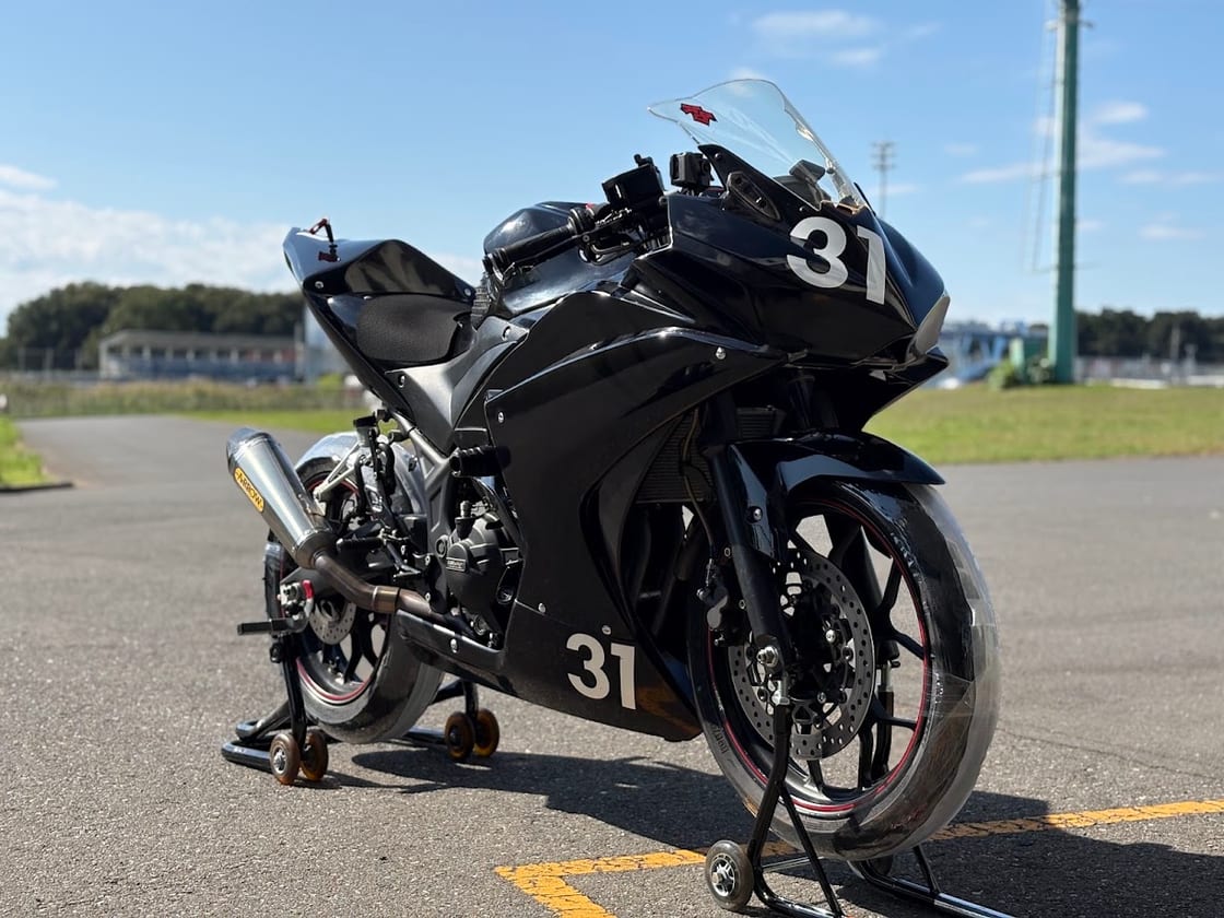 移植元のYZF-R25を右前方から。ゼッケン31の黒いカウルとARROWのマフラー
