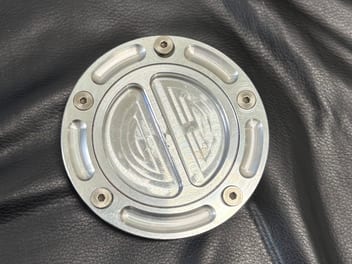アルミ製のタンクキャップ単体。外周にボルトが5本並ぶ