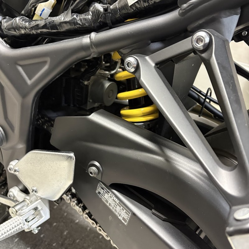 作業前のYZF-R3を左後方から。スイングアームの上に純正のチェーンガードが付いた状態
