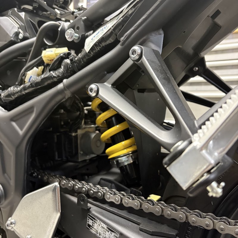 純正のチェーンガードを外したYZF-R3を左後方から。スイングアーム上面とドライブチェーンが露出している