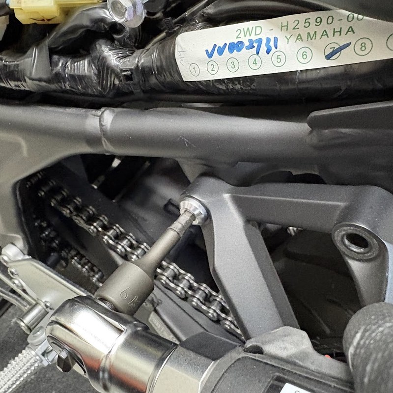 エクステンションバーを継いだラチェットで、左側のタンデムフットレストAss'yボルトを外しているところ