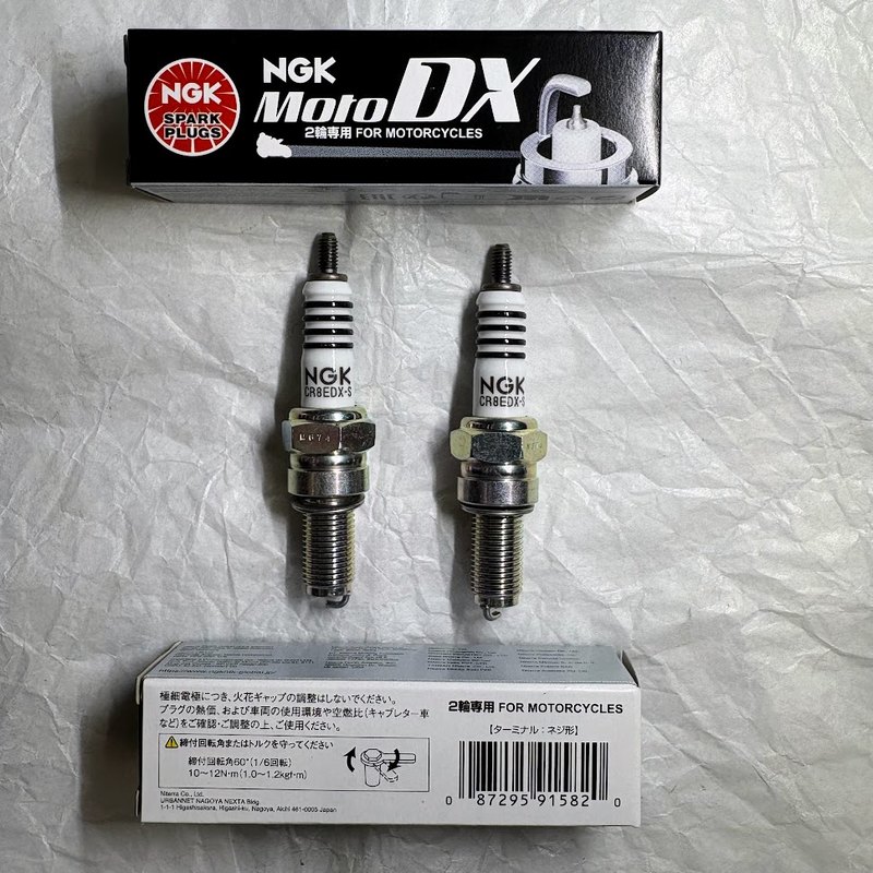 NGK MotoDX CR8EDX-S 2本と、上下に置いた製品箱。箱に締付回転角60度と10〜12N·mの表示がある