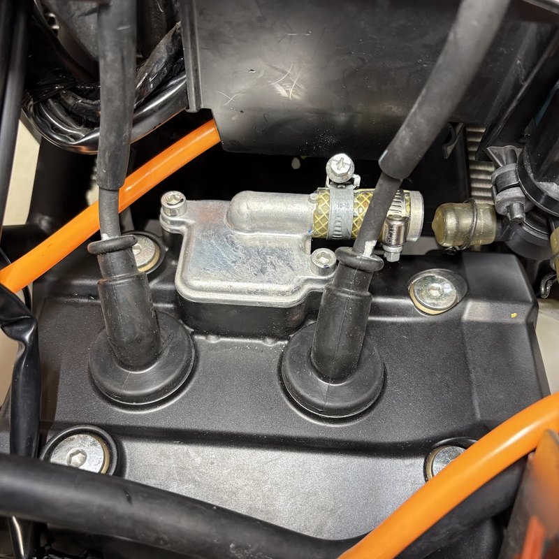 作業前のYZF-R3のシリンダーヘッドカバー。2つのプラグキャップと、その奥にアルミのフタをしたホースが付いたリードバルブカバー