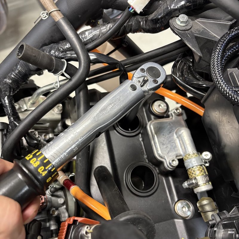 YZF-R3のスパークプラグを、トルクレンチを斜めに構えて締め付けているところ