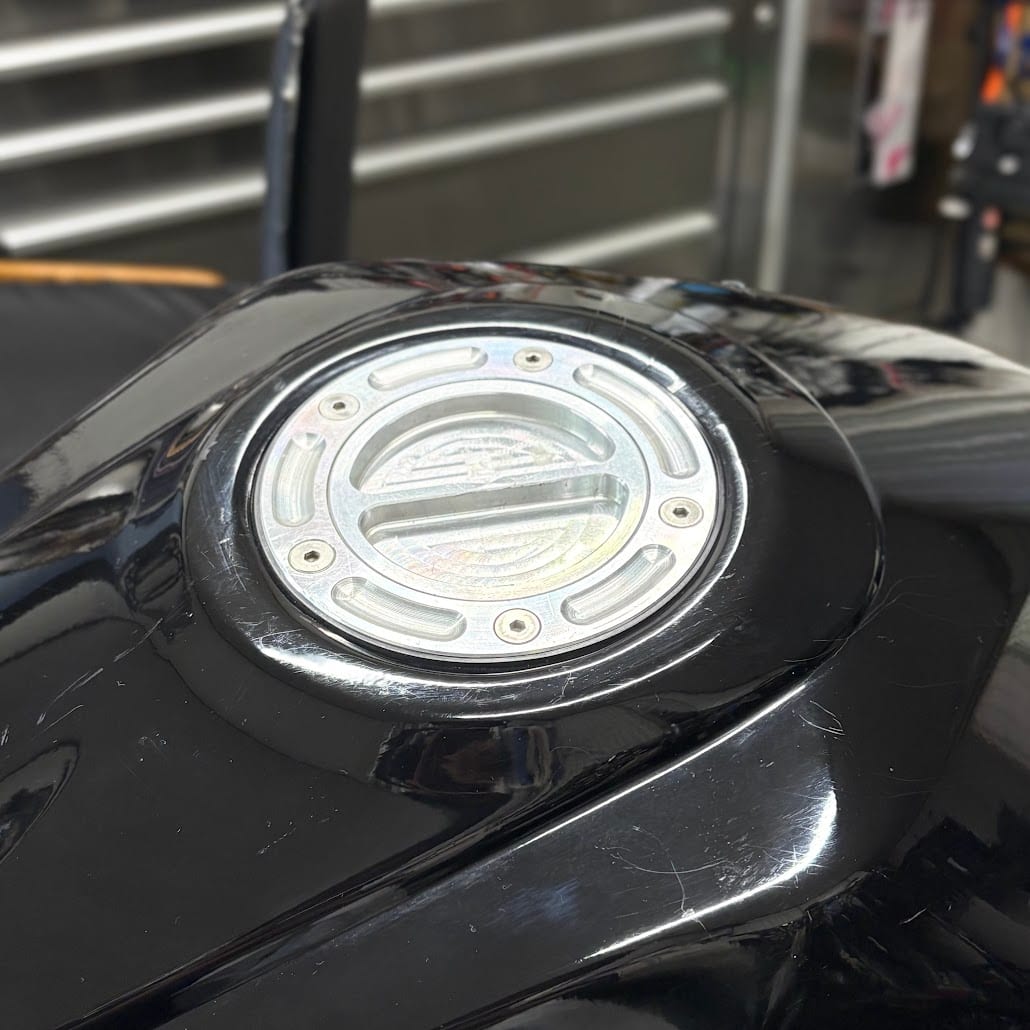 タンクカバーまで付け終えたYZF-R3のアルミ製タンクキャップ。外周にボルトが5本並ぶ