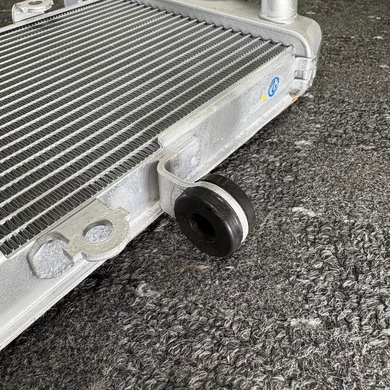 新品のラジエターの上側のステーに、グロメットをはめたところ