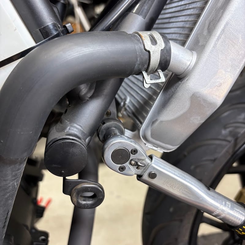 ホースをつないだあと、ラジエター側面の固定ボルトを締めているところ