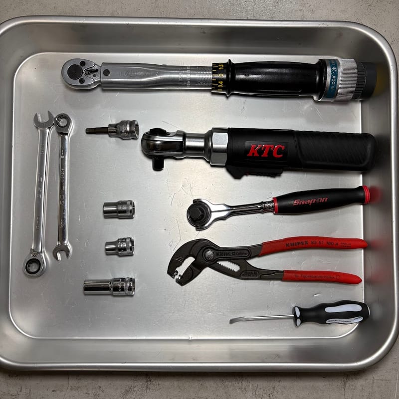 トレーに並べた工具。南海部品のトルクレンチ、KTC の電動ラチェット、スナップオンのラチェット、KNIPEX のホースクリップ用プライヤー、DEEN のシールリムーバー、SIGNET のギアレンチ2本、ソケット3個と六角のビットソケット