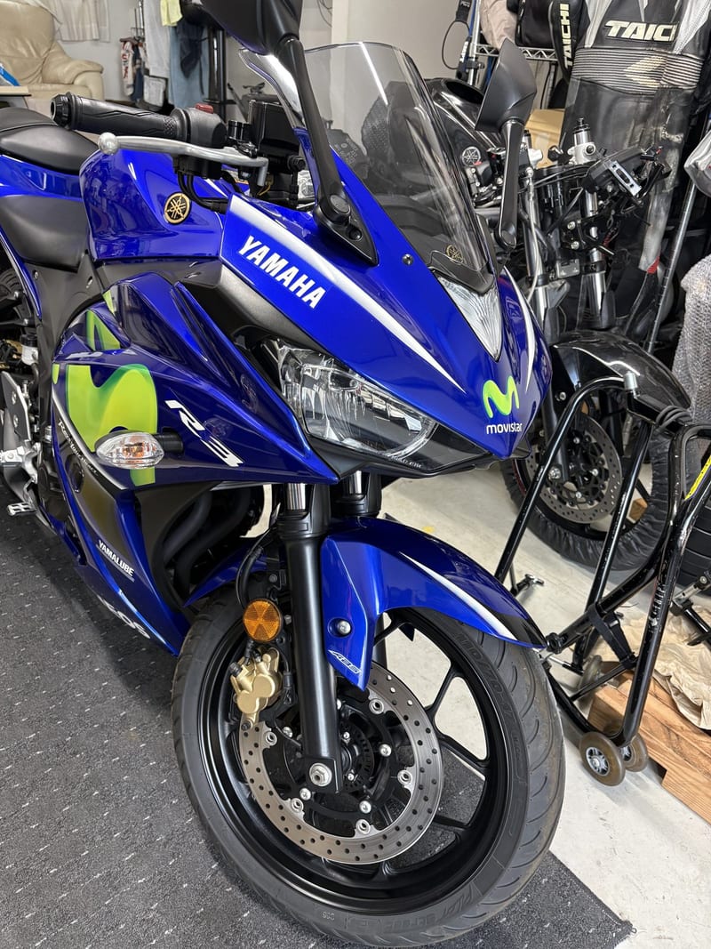 自宅ガレージに収めたYZF-R3を右斜め前から。フロントスタンドに載せた状態