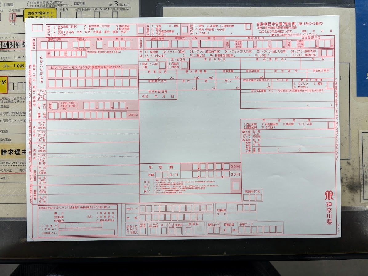 記入前の自動車税申告書(報告書)。神奈川県の赤い複写式用紙で、申告区分や運輸支局・車種区分・かな・番号などの記入欄がある