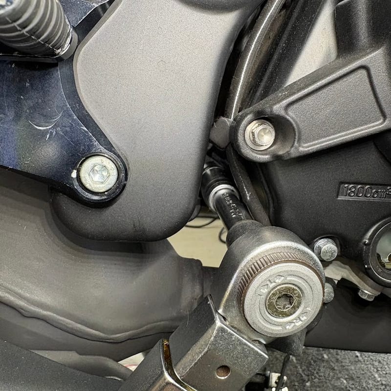 車体右側のエンジンマウントナット(後下側)を、ディープソケットとエクステンションを付けたトルクレンチで締めているところ