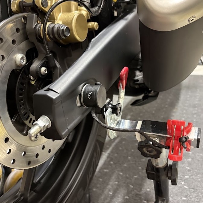 YZF-R3のスイングアームに差し込んだTOSH-TECのリアキャリパーサポートホルダー。黒い樹脂製の棒