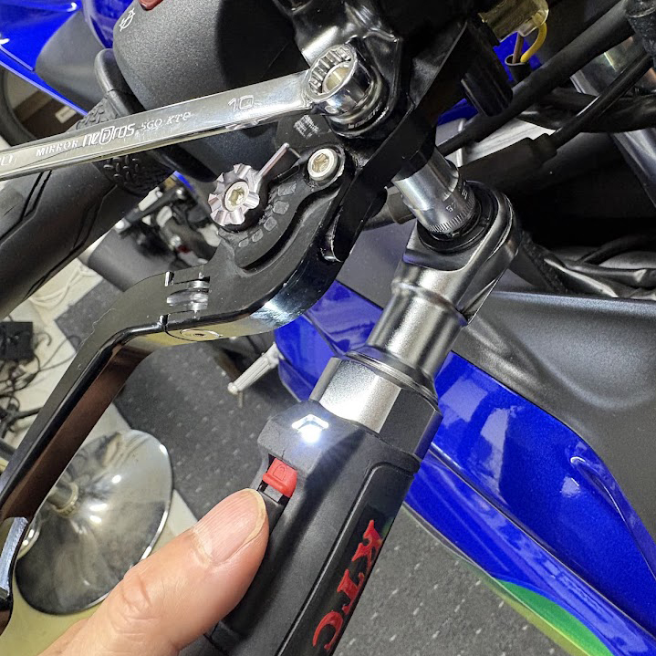 フロントブレーキレバーピボットボルトをレンチで締めているところ