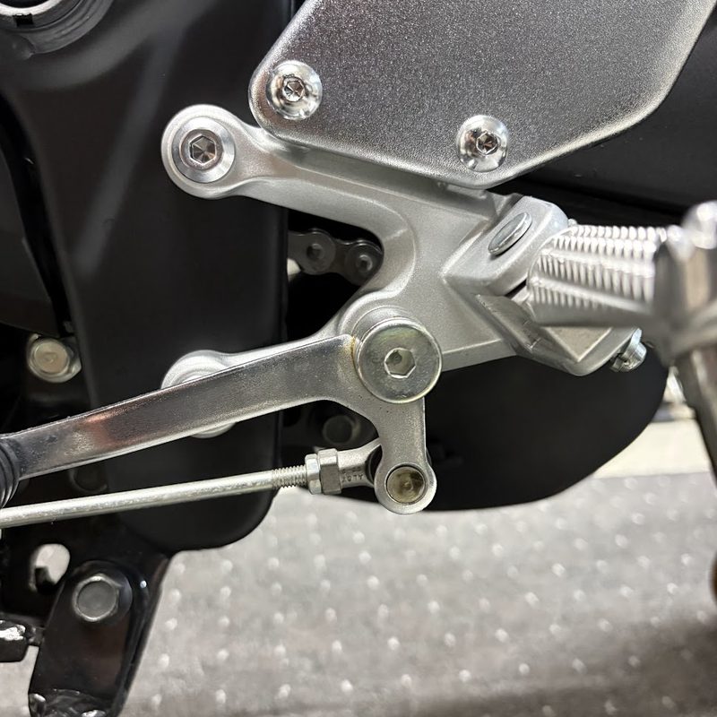シフトペダルの支点になっているボルト。左側フットレストブラケットの中央にある六角穴付きボルト